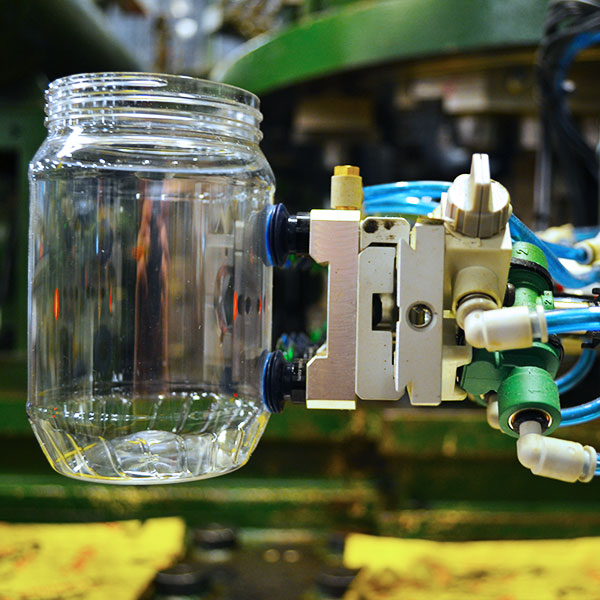Robotic palletizer gripper holding glass jar
