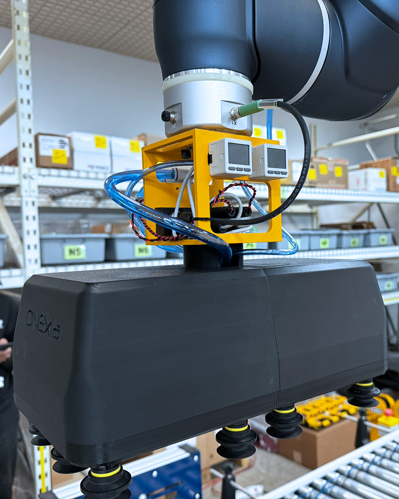 HD robotic palletizer with custom gripper in a manufacturing facility.